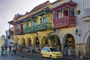 Vista de edificios coloridos en Cartagena, Colombia, con un taxi amarillo.