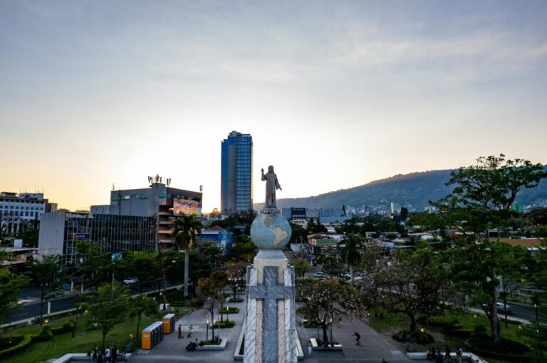 Estatua de Cristo en San Salvador con edificios y montañas al fondo