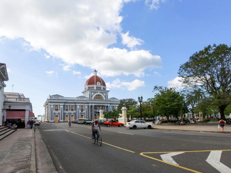 Vista de la Bahía de Cienfuegos con un edificio histórico y árboles