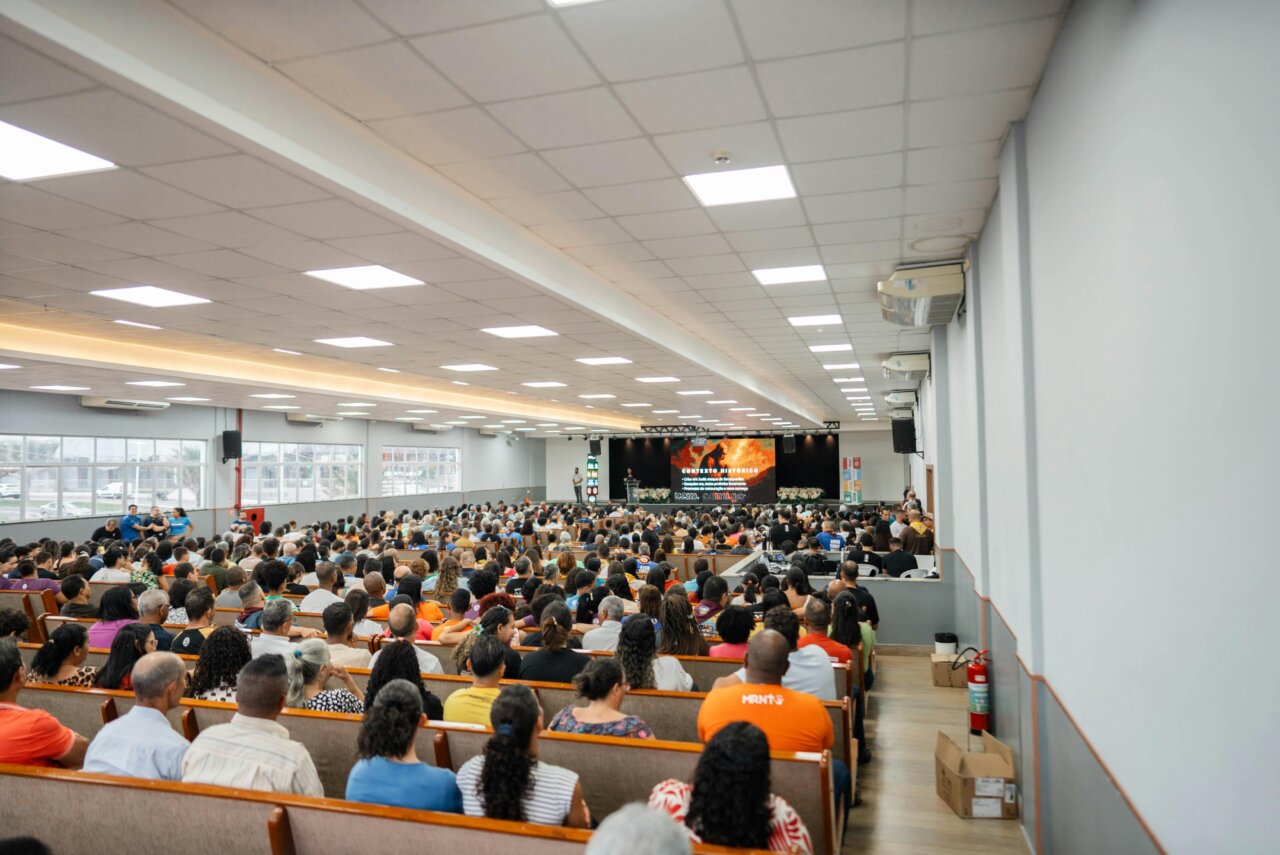 Vista del auditorio lleno durante una conferencia masiva con asistentes variados.