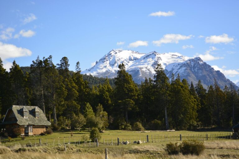 Vista panorámica de montañas nevadas y cabaña en Chubut
