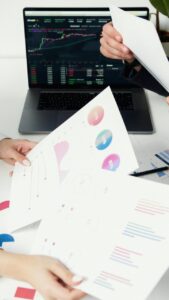 Personas revisando gráficos y documentos financieros en una oficina
