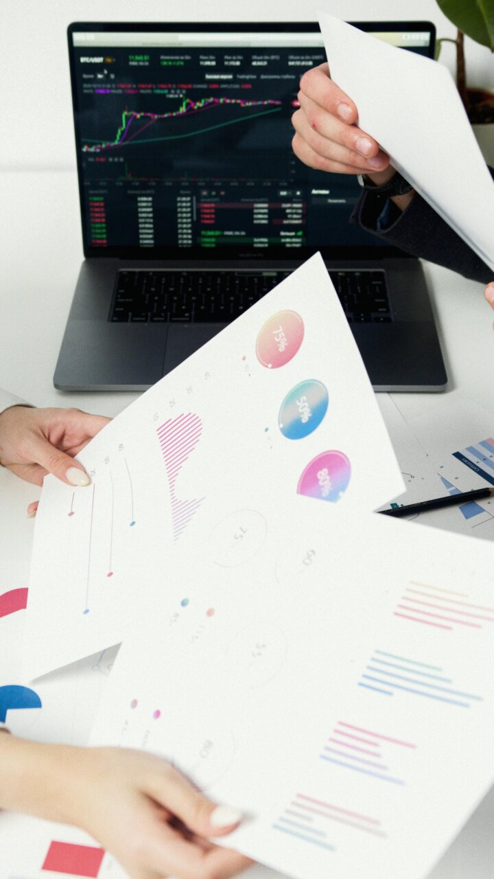Personas revisando gráficos y documentos financieros en una oficina