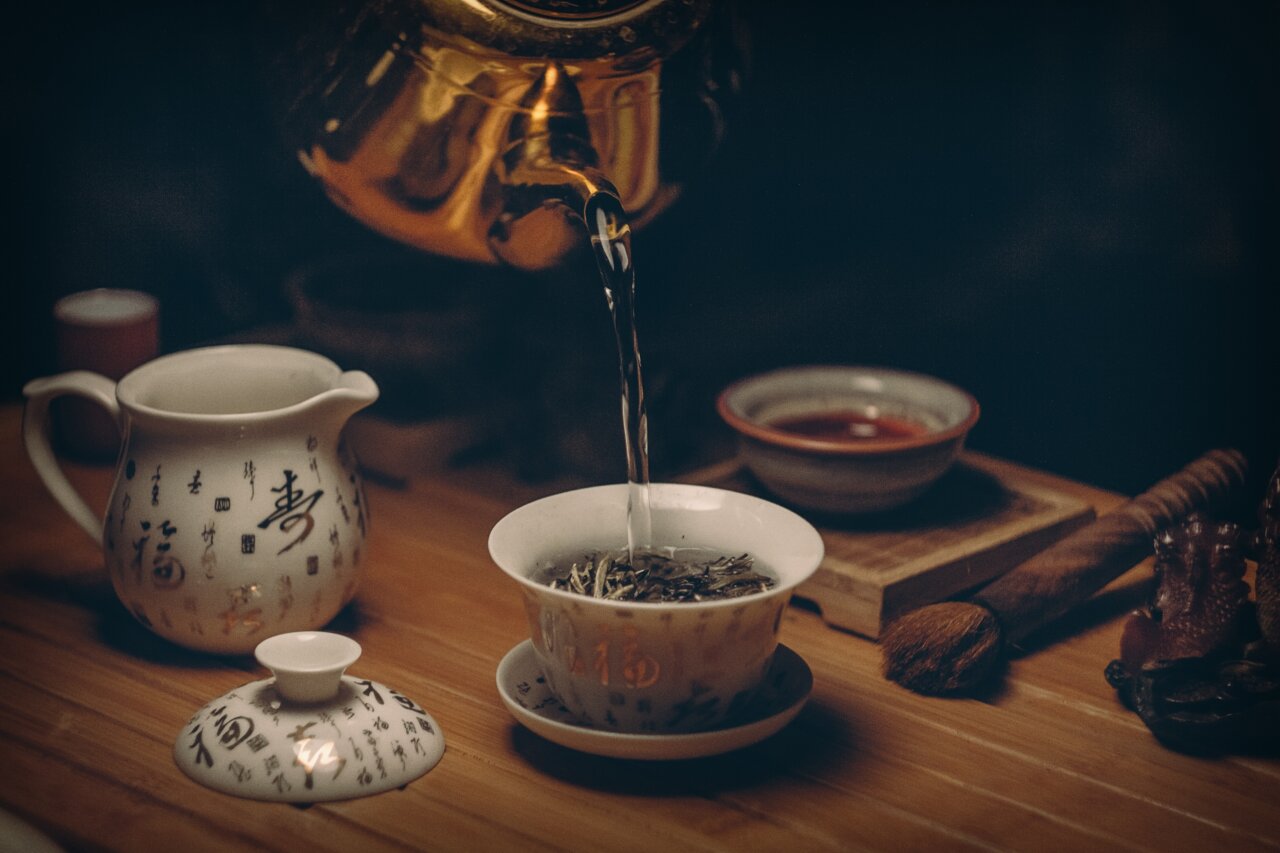 Té siendo servido en una taza con utensilios tradicionales
