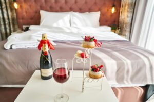 Habitación de hotel boutique con champán y postres decorativos