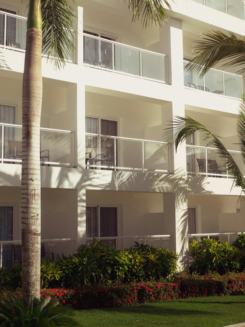 Vista de un hotel con balcones y jardín tropical