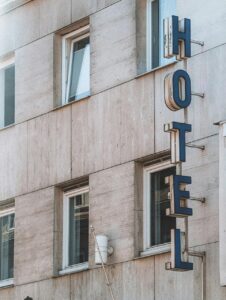 Fachada de un hotel con letrero visible en la pared.