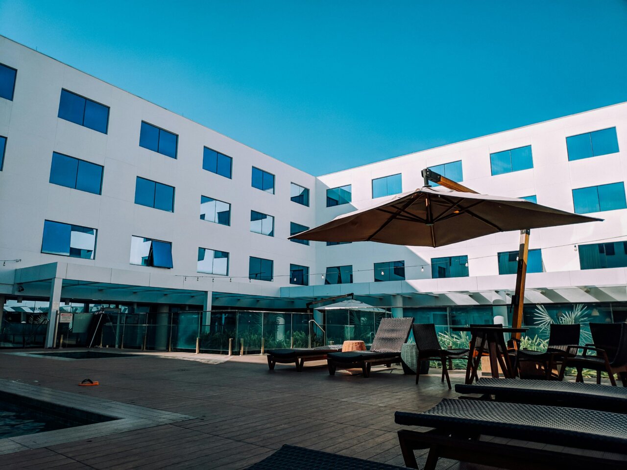 Vista de un hotel moderno con sombrillas y sillas de descanso