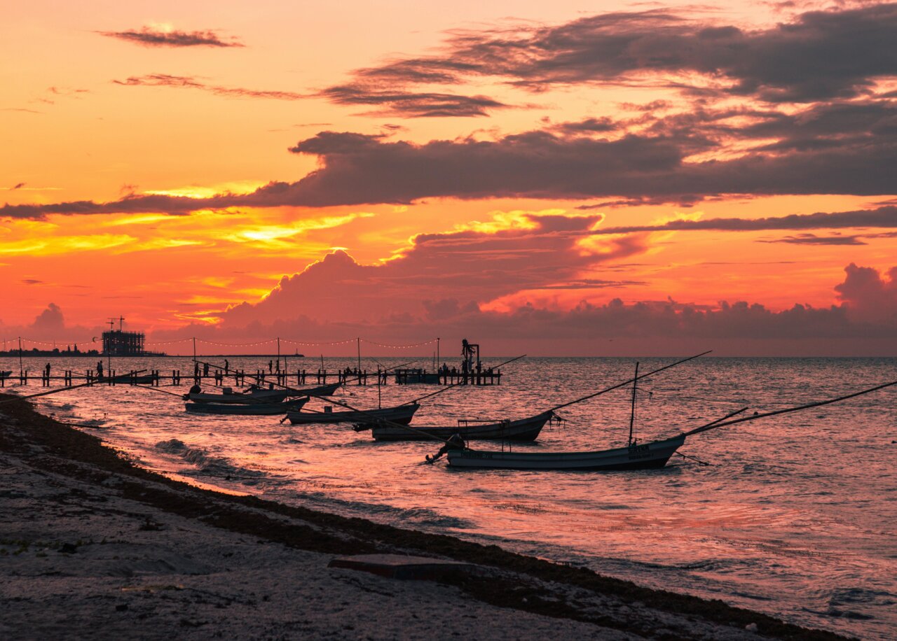 Atardecer en Yucatán con embarcaciones de lujo en la playa