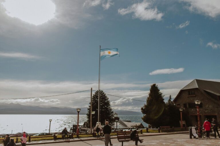 Vista de la bandera de Argentina ondeando en un paisaje costero