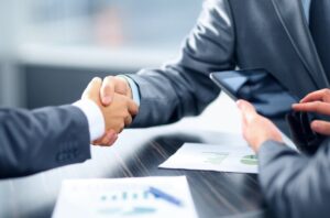 Dos personas estrechando manos en un entorno de negocios