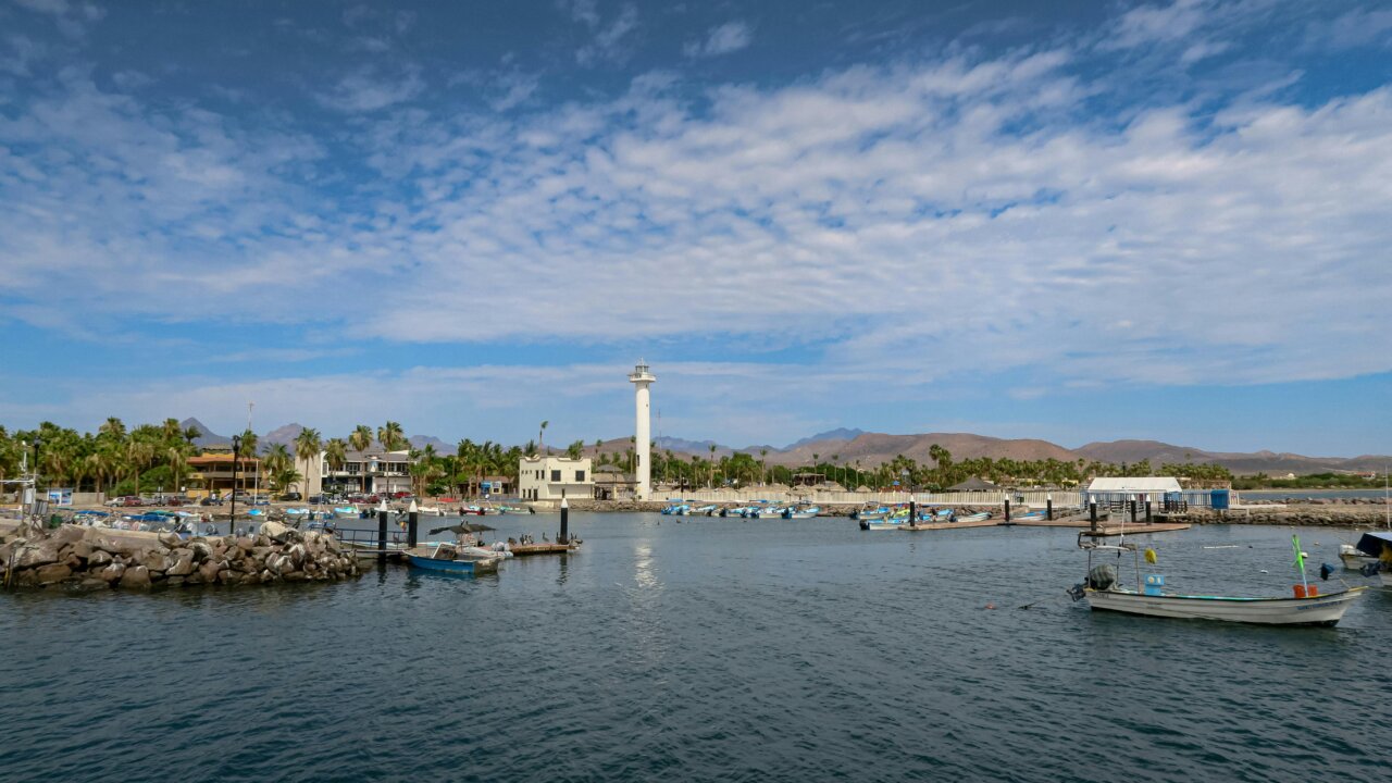 Vista del puerto en Loreto con barcos y faro