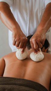 Terapia de masaje con bolsas en la espalda de un cliente