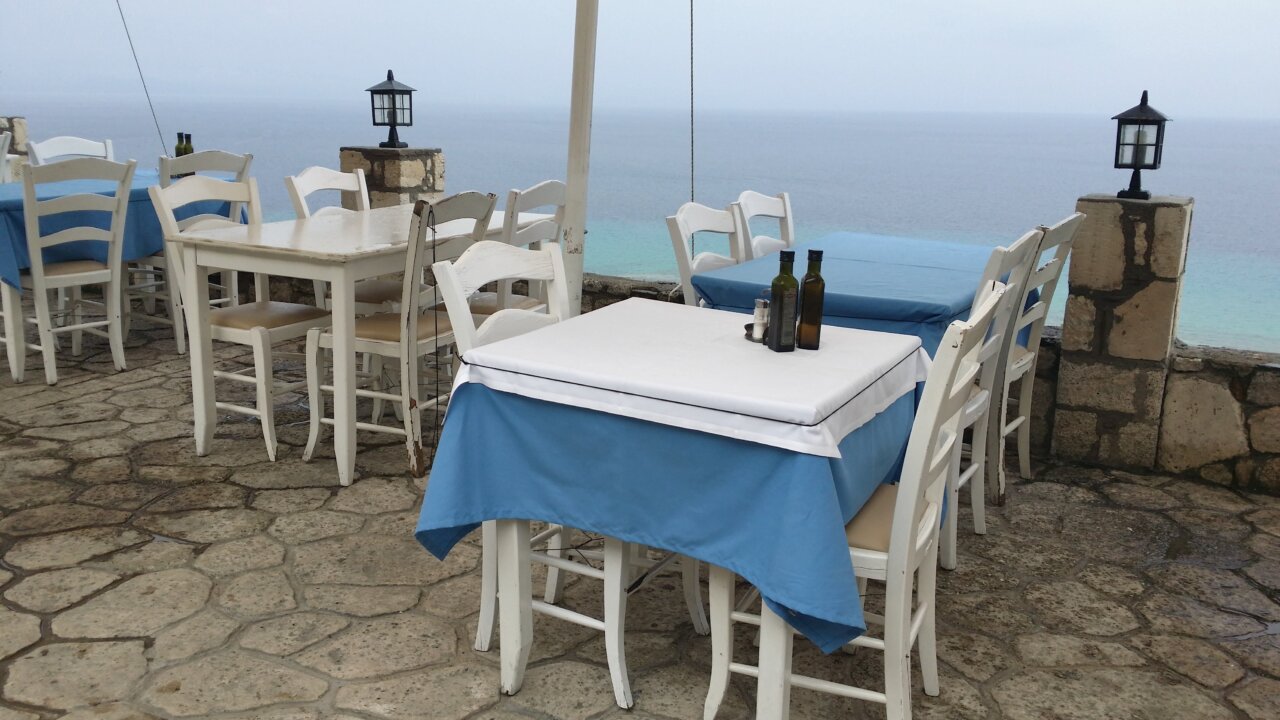 Mesa de un restaurante con vista al mar en un mirador turístico.