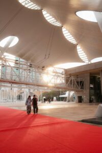 Personas caminando sobre una alfombra roja en un centro de convenciones moderno