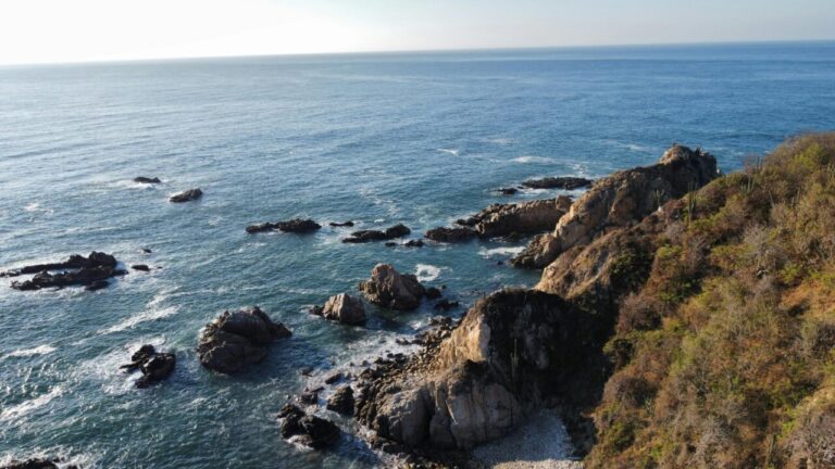 Vista aérea de un paisaje costero con rocas y mar azul