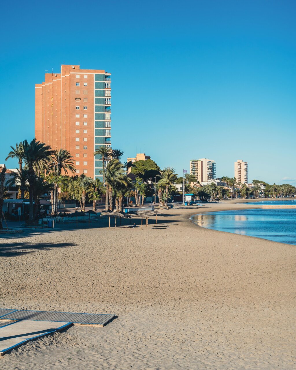 Vista de la playa en La Habana con edificios y palmeras