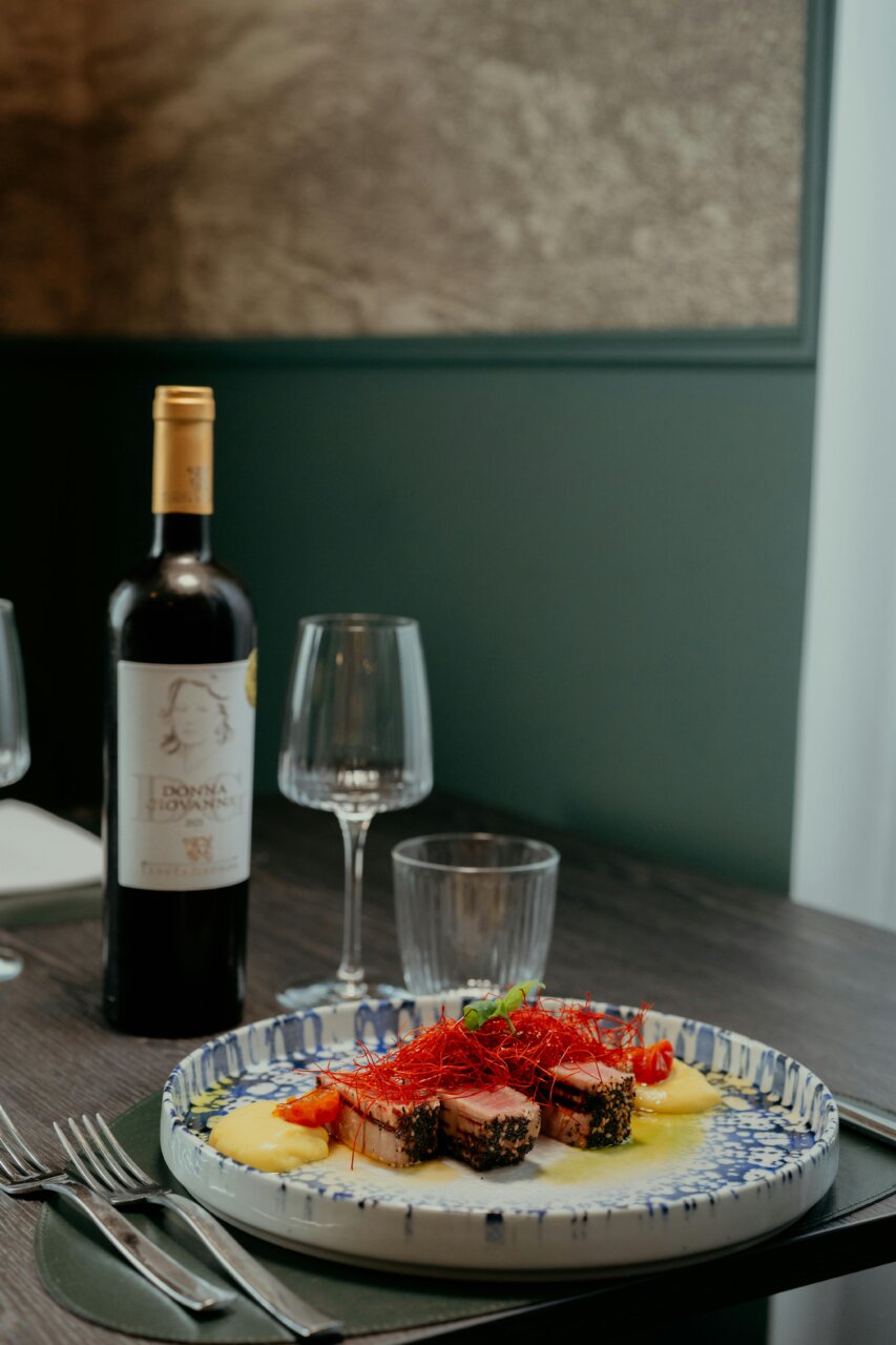 Plato gourmet con vino en un ambiente moderno de restaurante