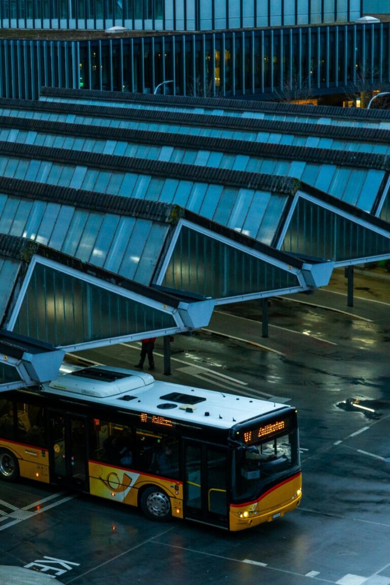 Vista de un autobús en una estación moderna con techos de vidrio.