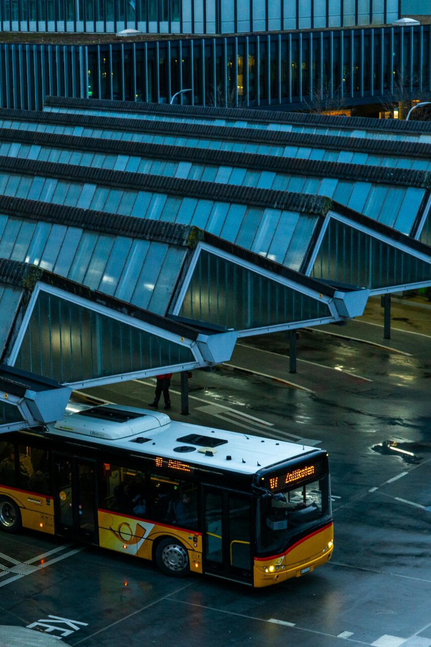Vista de un autobús en una estación moderna con techos de vidrio.
