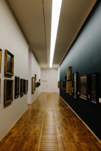 Pasillo del museo con cuadros en las paredes y luz moderna