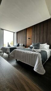 Habitación moderna en la Posada del Bosque con camas y decoración elegante