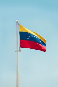 Bandera de Venezuela ondeando bajo un cielo azul claro