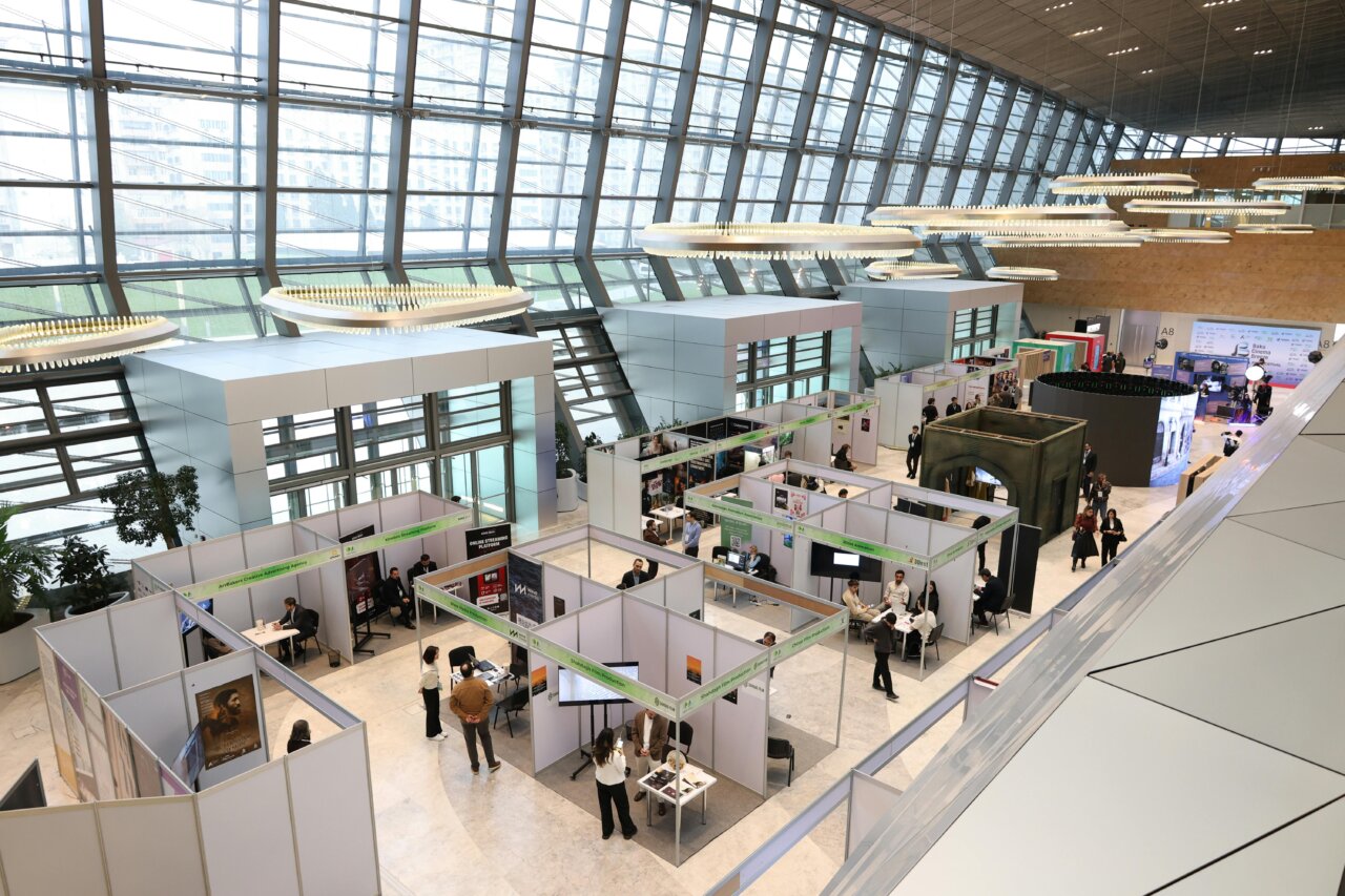 Vista aérea de un centro de exposiciones con stands y visitantes