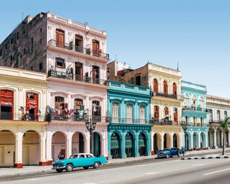Vista de edificios coloridos en La Habana, Cuba, con un coche clásico.