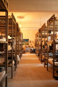 Interior de un hostal con literas y mesas de madera
