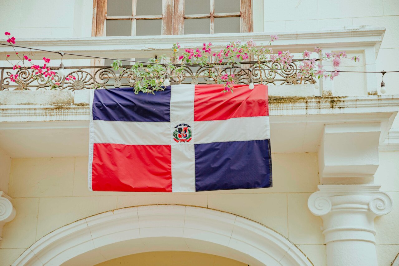 Bandera de la República Dominicana en un balcón con flores