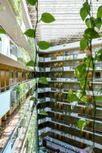 Vista interior de un hotel con plantas y diseño sostenible