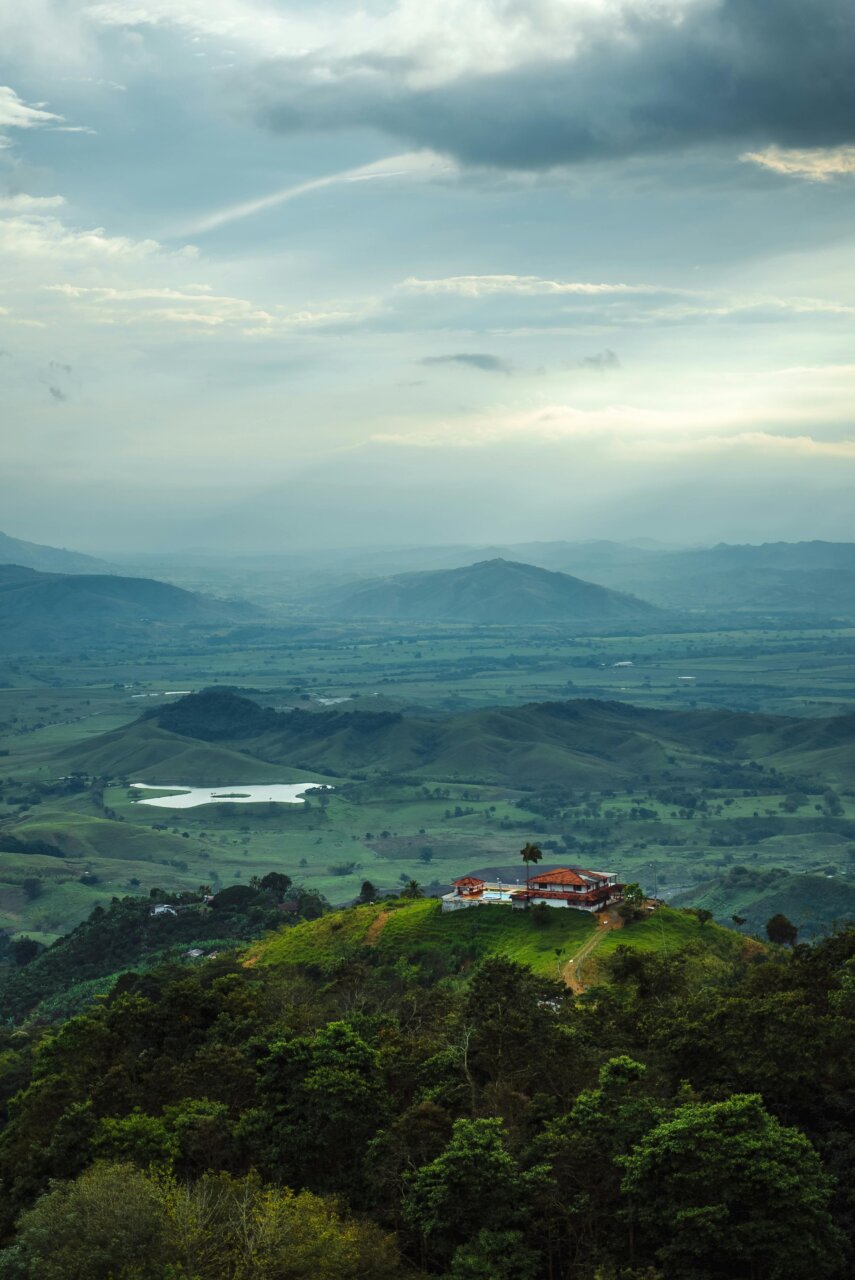 Vista panorámica de montañas con una casa en la cima